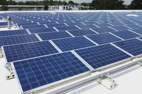 Technicians installing rooftop solar power system with panels and inverter setup for clean energy.