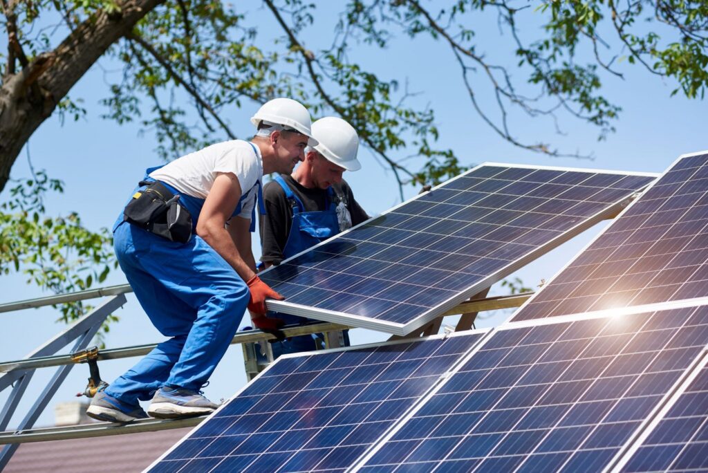 Residential solar panels on a home in Porvorim with technician inspecting inverter.